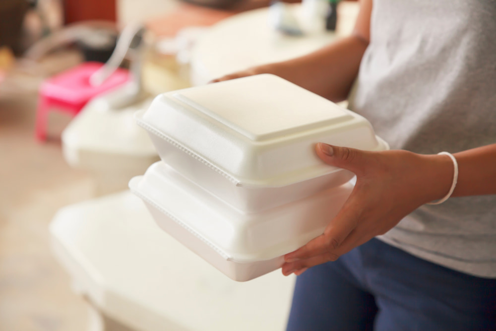 Woman carries foam food containers
